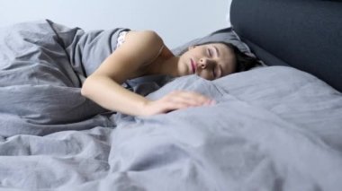 Evde boş bir yatakta tek başına uyanan bir kadın. Genç bir bayan otel odasında yalnız uyanır. İzole edilmiş üzgün bir kız boş yatakta yatıyor. Yalnızlık kavramı. Kalbi kırık bir kadın boş bir odada yatıyor.