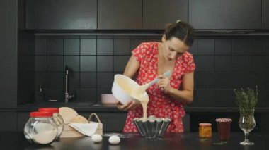 Profesyonel şef un içinde hamur pişiriyor ve hazırlıyor. Modern mutfakta turta pişiren bir kadın. Genç ve çekici bir bayan mutfakta yemek yapıyor. Ev hanımı tek başına mutfakta pasta pişiriyor.