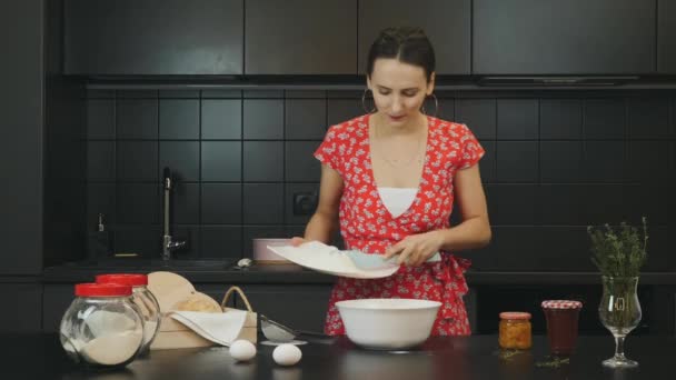 Mulher atraente cozinhar biscoitos caseiros na cozinha moderna. Jovem fêmea feliz está misturando ingredientes para bolo na cozinha profissional. Linda dona de casa em casa cozinha. Conceito de estilo de vida saudável — Vídeo de Stock