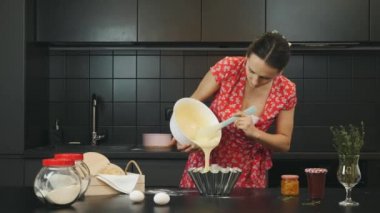 Ev hanımı modern mutfakta turta hazırlıyor. Kadın hamuru fırın tabağına döküyor. Kadın yemekleri ev yapımı tatlı turta. Ev yemeği konsepti. Sağlık ve sağlık yaşam tarzı kavramı