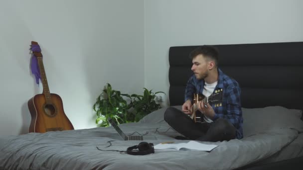 Kytarista učí novou píseň doma v obývacím pokoji. Muž hraje na elektrickou kytaru. Millennial hraje svou novou píseň na kytaru. Mužský hudebník cvičí baladu. Hudební koncept — Stock video