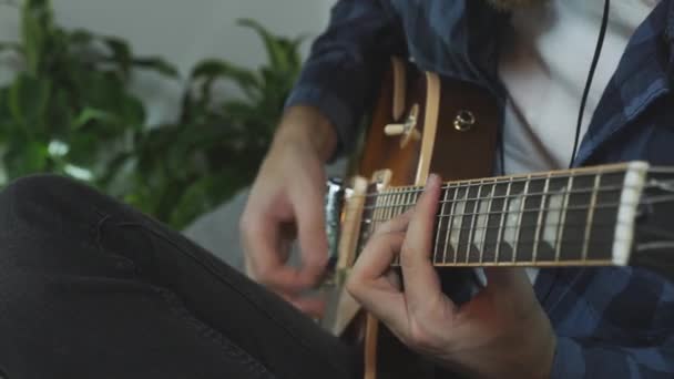 Um homem a tocar guitarra eléctrica. Mãos tocando e mudando acordes na guitarra. Conceito musical — Vídeo de Stock