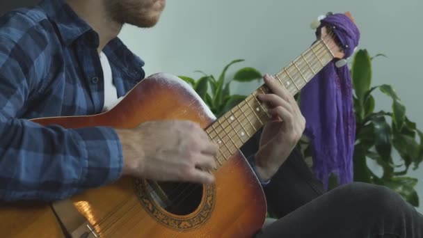 Молодий успішний музикант грає на акустичній гітарі вдома практикує і складає пісню . — стокове відео