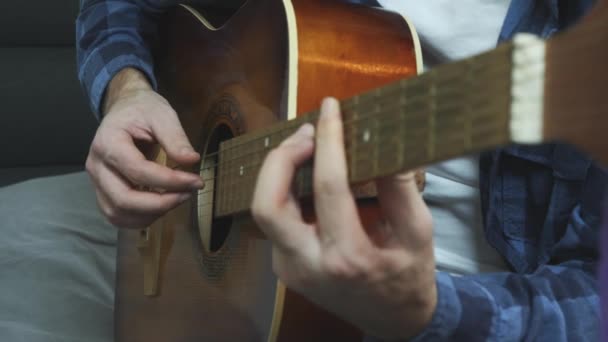 Erkek eller akustik gitarla akor çalıyorlar. Müzisyen ellerinin akustik gitarla çalışını yakından izle. — Stok video