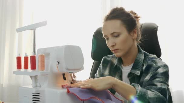 Mulher designer de moda costurar na máquina de costura. Menina bonita jovem costurando um vestido. Criação e alfaiataria de roupas. Conceito de moda — Vídeo de Stock