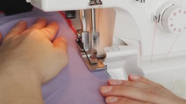 Terzi dikiş makinesine kumaş dikiyor. Kadın eli dikiş yıpranmış. Kumaş dikme atölyesi. Yaratılış ve terzilik kıyafetleri. Moda konsepti