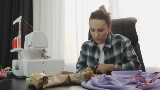 Vrouwelijke modeontwerper werkt met schaar en stof in de studio van de kleermaker. Vrouw die jurk en naaiwerk maakt. Creatie en kleding op maat. Modeconcept — Stockvideo