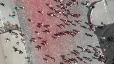 Kyiv/Ukraine - June 2, 2019 - Females and males jogging at Color Run Kyiv festival. Happy sportive people running at run race, drone top view. Participants run on city center