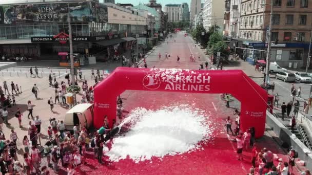 Kyiv/Ukraine - June 2, 2019 - Drone flying at Color Run Kyiv festival. Happy active participants of competition staying at arch "Turkish Airline". — Stockvideo