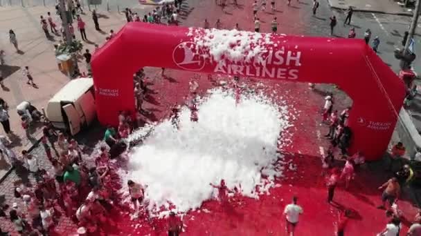 Kiev / Ucrania - 2 de junio de 2019 - Drone volando alrededor del arco de la línea de meta "Turkish Airlines" en Color Run Kyiv. Deportivas mujeres y hombres felices de pie en la línea de meta de la competencia de carrera — Vídeos de Stock