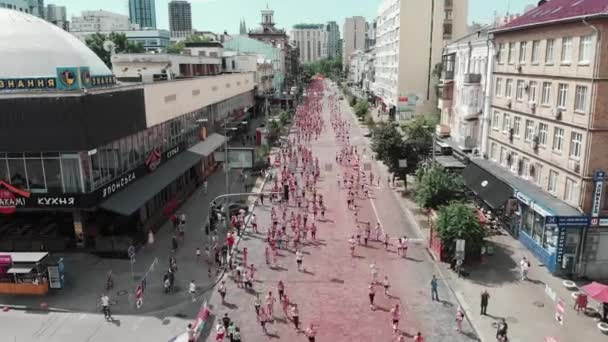 Kyiv/Ukraine - June 2, 2019 - Sporty happy participants smeared colorful fluorescent holi paints running at Color Run Kyiv on street of the center of town. People taking part in run competition — Stock Video