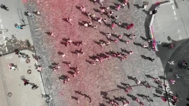 Kyiv/Ukraine - June 2, 2019 - Females and males jogging at Color Run Kyiv festival. Happy sportive people running at run race, drone top view. Participants run on city center — ストック動画