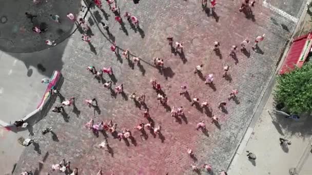 Kiev / Ucrania - 2 de junio de 2019 - Vista superior de la gente corriendo en la calle del centro de la ciudad untó coloridas pinturas de holi en el festival Color Run Kyiv. Mujeres y hombres trotando en la competencia de carrera — Vídeos de Stock