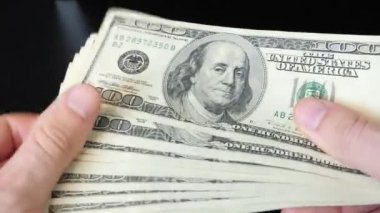 Amerikalıları elinde 100 dolarlık kağıt para yığını tutan adam. Erkeklerin elinde nakit para var. Nakit para ödemesi. Başarılı iş konsepti. Finans ve para ödeme kavramı