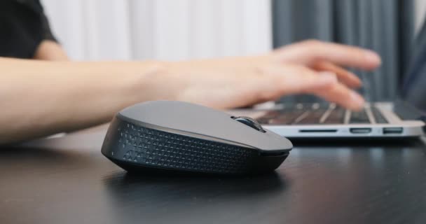 Крупним планом чорна комп'ютерна бездротова миша. Жінка працює на ноутбуці за допомогою миші, додатково крупним планом. Концепція успіху бізнесу — стокове відео