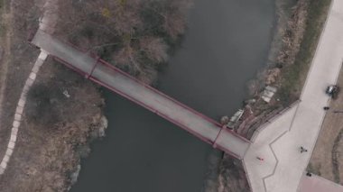 Kadın köprüden karşıya nehir ve havadan manzarayla koşuyor. Dışarıda egzersiz yapan bir kadın. Parkta gezinti güvertesi ve köprüyle koşan bir kızın robot resmi. Spor ve kilo verme konsepti