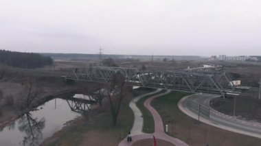 İnsansız hava aracı nehir ve turist güvertesiyle demiryolu üzerinde uçuyor. Yaya yolları ve rıhtımı olan nehrin havadan görünüşü