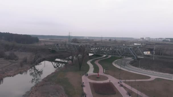 Vue aérienne de la promenade touristique le long de la rivière. Drone vole au-dessus du parc avec quai et sentiers pédestres — Video