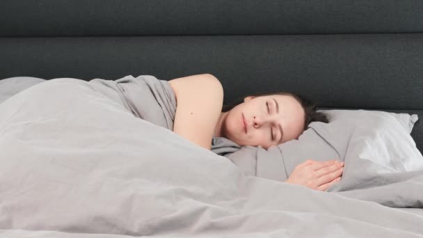 Mujer durmiendo sola en la cama. Mujer joven aislada está durmiendo en la sala de estar vacía. Concepto de estilo de vida — Vídeos de Stock