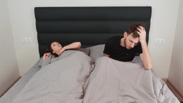 Jeune femme déprimée et stressée couchée sur le lit. Couple marié souffrant d'insomnie à cause de problèmes sexuels. Femme et homme couchés dans la chambre. Crise dans les relations — Video