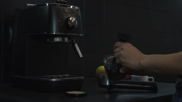 Близько бариста роблять каву. Жіночі руки тримають утримувач фільтра з меленою кавою. Жінка готує каву американо. Концепція харчування та напоїв — стокове відео