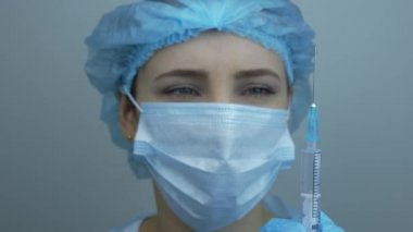 Koronavirüs aşısını tedavi et. NCoV Coronavirus aşısı olan bir şırınga tutuyor. 2019-nCoV COVID virüsü için. Virüs enfeksiyonunu önlemek için şırıngayla ilaç tutan hemşire.