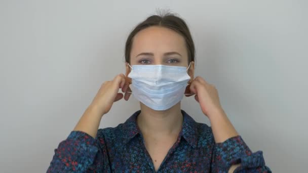 Woman takes off protective medical mask and hard breathing, in panic of epidemic virus, danger of coronavirus pandemic 2019-ncov. Young girl taking off medical mask after quarantine. — Stock Video