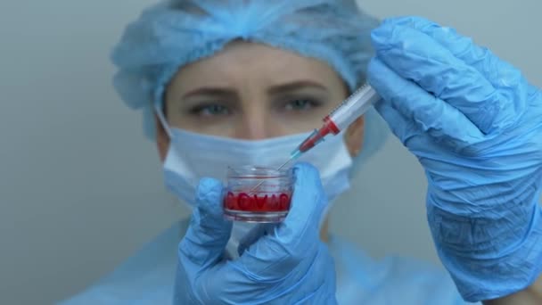 Enfermera sosteniendo tubo con vacuna contra el coronavirus para el virus COVID 2019-nCoV. Trabajador médico que prepara la jeringa para inyección para la prevención de infecciones por virus. Mujer sostiene tubo de ensayo con medicamentos preventivos — Vídeo de stock