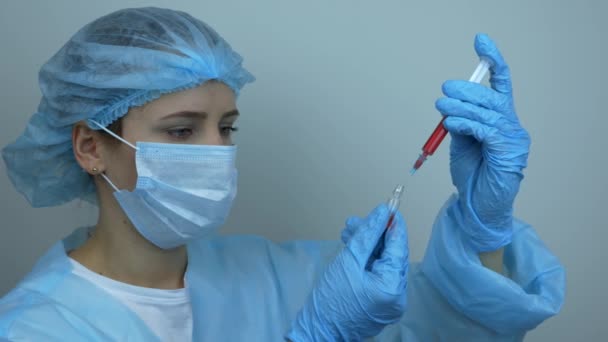 Young caucasian scientist takes samples for Covid 19 vaccination, Coronavirus vaccine for 2019-nCoV COVID virus. Female laborant holding medical tube with samples of vaccine. Preventive medications — Stock Video