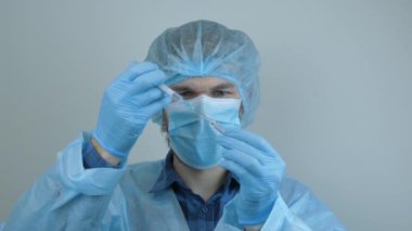 2019-nCoV COVID virüsü için koronavirüs aşısı yapılmış erkek laboratuvar tüpü. Doktor virüs enfeksiyonunu önlemek için şırınga hazırlıyor. Adam önleyici ilaçlarla test tüpü tutuyor.
