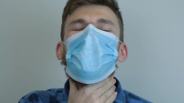 Tıbbi maske takan hasta genç adam kan öksürüyor. Tüberküloz salgını. Covid-19 koronavirüsünün pandemik koruması. Virüs koruması