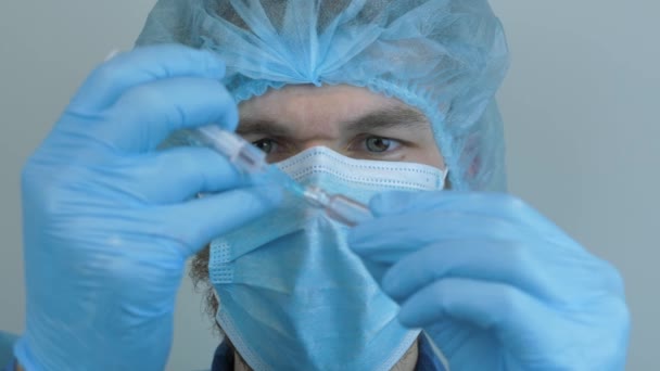 Doctor in protective gear taking samples for Coronavirus vaccine for 2019-nCoV COVID virus. Male medical worker with syringe for injection. Man takes blood samples for prevention of viral diseases — Stock Video