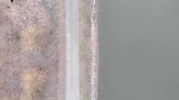 Sentier piétonnier isolé vide le long du barrage, vue aérienne. Passerelle touristique avec rivière. Route étroite le long du lac, tir de drone — Video