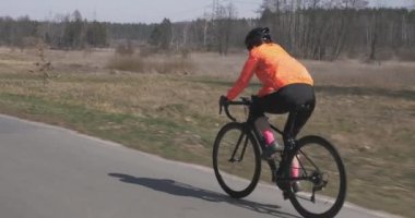 Bisiklet süren bir kadın. Yol bisikleti süren bir kadın. Sporcu sıkı çalışıyor. Triatlon konsepti