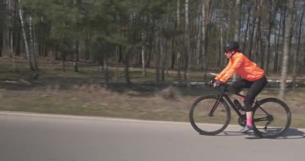 Girl intensively cycling on road bike. Woman rides on bicycle. Female pedaling  on cycle. Triathlon concept — Stock Video