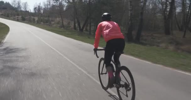 自転車で上ります。自転車で自転車に乗る女性。女が乗ってる。選手は自転車で一生懸命ペダルを漕いでいる。自転車でのトライアスロントレーニング。トライアスロンのコンセプト — ストック動画