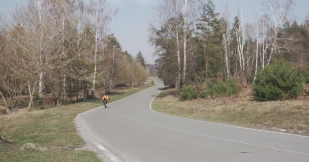 Mujer en bicicleta cuesta arriba. Mujer en casco montando en bicicleta. Atleta monta al aire libre. Chica deportiva entrenando en bicicleta. Ciclista pedaleando en bicicleta. Concepto de triatlón — Vídeos de Stock