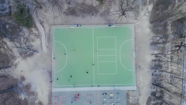 La gente juega al fútbol. Juego de fútbol en el campo, vista de arriba hacia abajo. Juego de fútbol, tiro con dron. Vista aérea de dos equipos jugando al fútbol al aire libre. Concepto deportivo — Vídeos de Stock