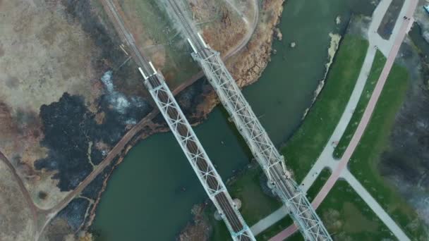 Hochgeschwindigkeitszuggleise auf einem erhöhten Bahnsteig. Moderne Eisenbahnen über den Fluss. Drohne kreist über Eisenbahnbrücke aus Metall — Stockvideo