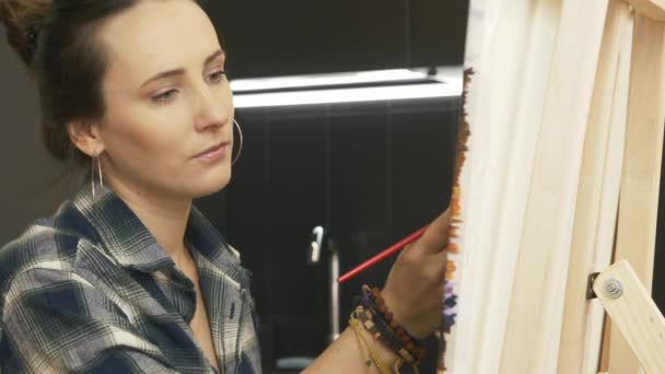 Mladá inspirovaná umělkyně kreslí obraz na plátně akrylovými barvami. Ženská malba doma, portrét. Bruneta talentovaná dívka vytváří abstraktní moderní umění — Stock video