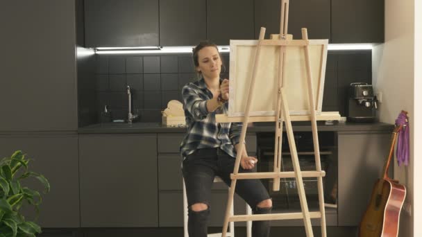 Talentueuse artiste féminine inspirée peinture sur toile dans la cuisine moderne à la maison. Image de dessin de femme en utilisant des peintures acryliques à la maison. Peintre créateur d'art moderne. Thérapie d'art domestique. Inspiration — Video