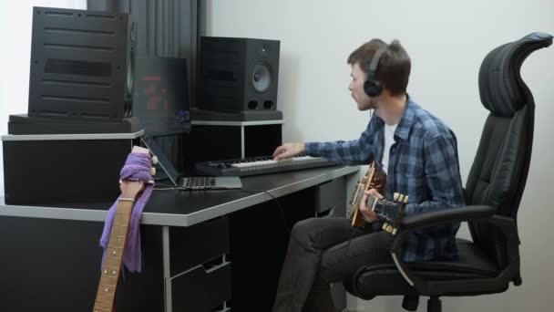 Skladatel skladatel hraje na midi klavír klávesnice doma hudba nahrávací studio drží elektrickou kytaru. — Stock video