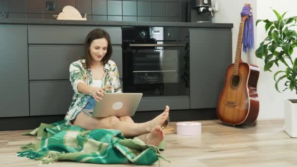 Mujer usando el ordenador portátil durante el trabajo en el proyecto remoto en casa. Chica joven con la computadora, charlando con amigos en línea en la red social, respondiendo mensajes de correo electrónico en el acogedor estudio de casa . — Vídeo de stock