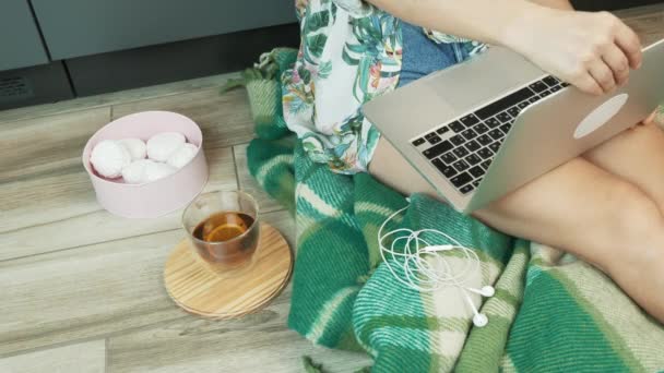 Vrouwelijke openen laptop computer en beginnen te typen op het toetsenbord zitten op de vloer thuis werkplek studio. Vrouw die thuis blijft en werkt tijdens een coronavirus pandemie. Afstandswerk in quarantaine — Stockvideo