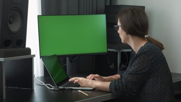 Femeie angajat care lucrează pe laptop-ul de la locul de muncă acasă. O femeie de afaceri încrezătoare și concentrată lucrează la birou acasă pe calculator. Femeie în ochelari tastând pe tastatura computerului și făcând treabă la distanță — Videoclip de stoc