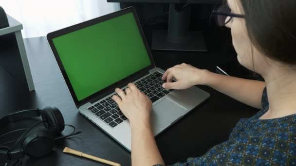Жіночі пальці, що друкуються на клавіатурі ноутбука, крупним планом. Фокусована бізнес-леді, що працює на ноутбуці і дивиться на екран ноутбука з віддаленого робочого місця. Жінка працює на комп'ютері в офісі — стокове відео