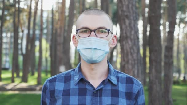 Een man die een beschermend gezichtsmasker afdoet, diep ademt en glimlacht, portret. Coronavirus covid-19 quarantaine. Virusbescherming. Epidemische preventie. Begrip gezondheid en veiligheid — Stockvideo