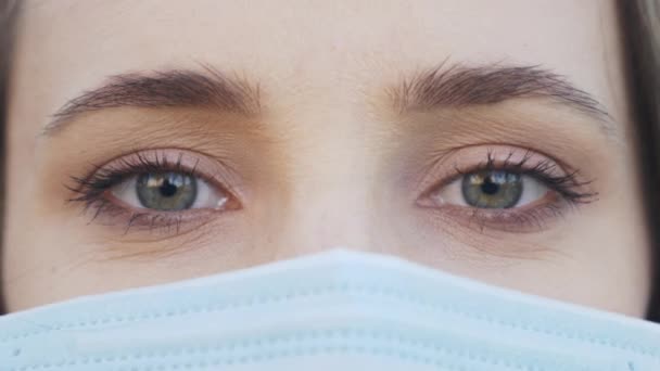 Jonge vrouw met een beschermend medisch gezichtsmasker in quarantaine tijd voor virusinfectie preventie en bescherming. Angst voor een epidemisch virus. Coronavirus covid-19 pandemie. Portret van meisje met gezichtsmasker — Stockvideo