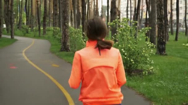 Jeune femme fitness jogging seul dans le parc de la ville vide le matin le jour de pluie. Exercices sportifs quotidiens du matin. Entraînement de coureuse sportive dans le parc. Face arrière de la femme athlète jogging extérieur 