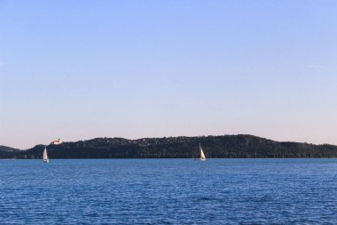 Bir yat ya da tekne denizde ya da okyanusta yol alır. Mavi sakin deniz, güzel gökyüzü. Ekran koruyucu, arkaplan veya kartpostal
